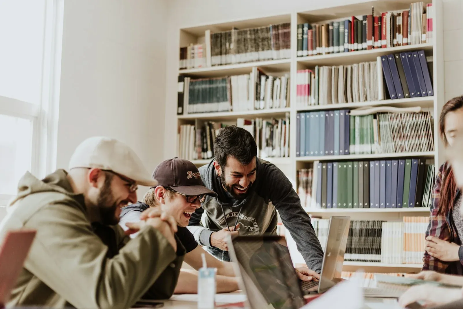 Four university students studying together around a library table